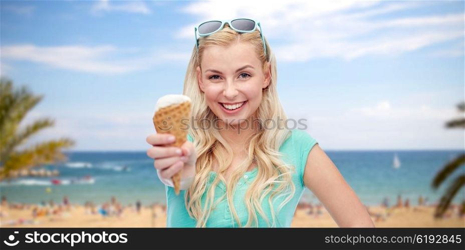 summer holidays, travel junk food and people concept - young woman or teenage girl in sunglasses eating ice cream over exotic tropical beach with palm trees and sea background
