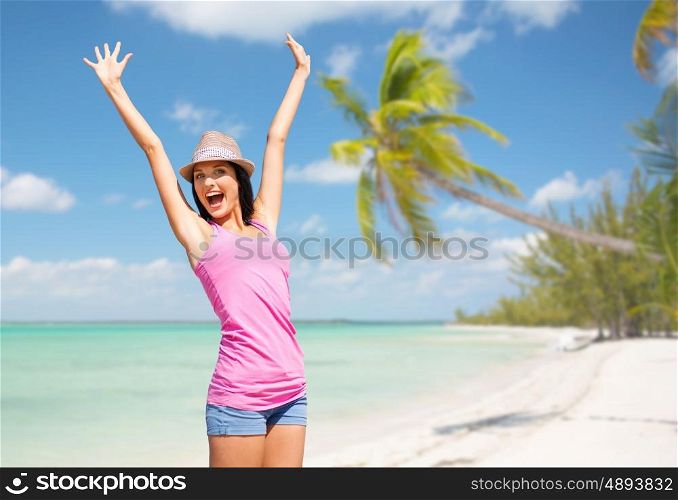 summer holidays, travel, people and vacation concept - happy young woman in hat over exotic tropical beach with palm trees and sea shore background