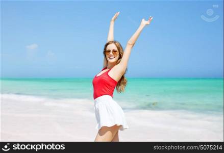 summer holidays, travel, people and vacation concept - happy young woman in sunglasses over exotic tropical beach background. happy young woman in sunglasses on summer beach
