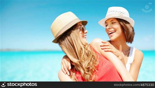 summer holidays, travel, people and vacation concept - happy young women in hats over exotic tropical beach background