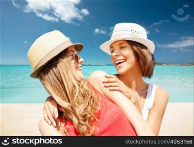 summer holidays, travel, people and vacation concept - happy young women in hats over exotic tropical beach background. happy young women in hats on summer beach