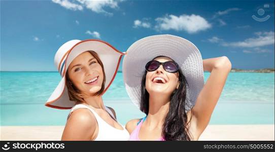 summer holidays, travel, people and vacation concept - happy young women in hats over over exotic tropical beach background. happy young women in hats on summer beach