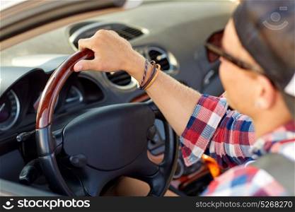 summer holidays, travel, road trip and people concept - close up of happy young man in sunglasses and cap driving car. close up of happy man driving car