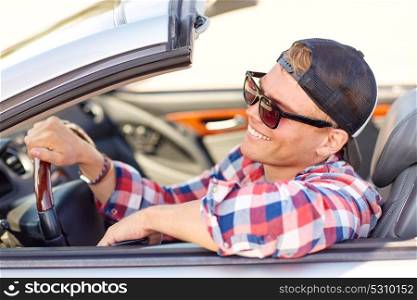 summer holidays, travel, road trip and people concept - happy smiling young man in sunglasses and cap driving convertible car. happy young man in shades driving convertible car