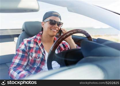 summer holidays, travel, road trip and people concept - happy young man calling on smartphone in convertible car. happy man calling on smartphone in convertible car