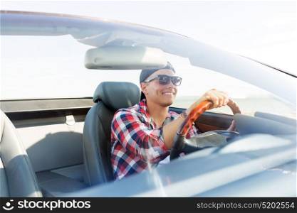 summer holidays, travel, road trip and people concept - happy young man driving convertible car. happy young man driving convertible car