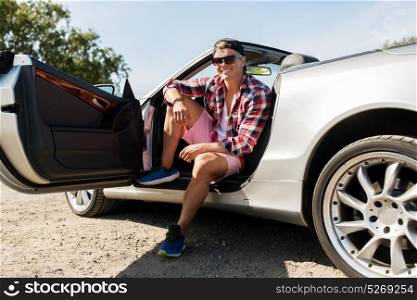 summer holidays, travel, road trip and people concept - happy young man sitting in convertible car. happy young man sitting in convertible car