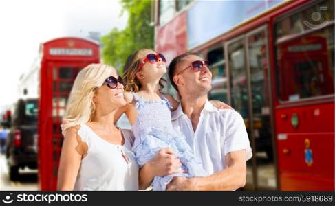 summer holidays, travel, tourism and people concept - happy family in sunglasses looking up over london city street background