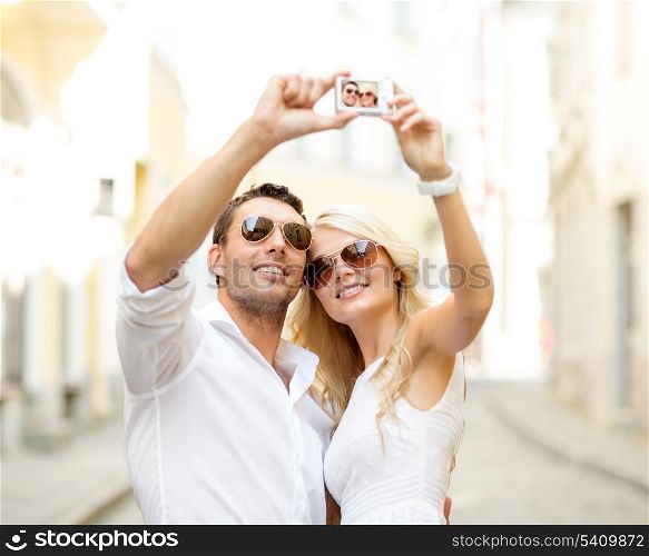 summer holidays, travel, vacation, tourism and dating concept - travelling couple taking photo picture with camera