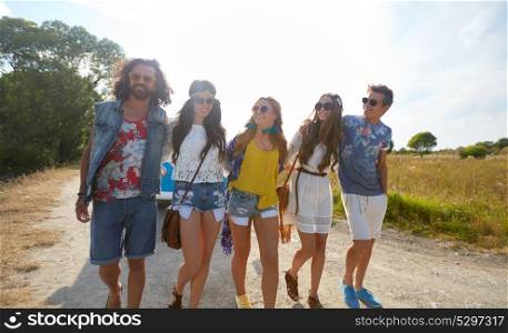 summer holidays, trip, travel and people concept - smiling happy young hippie friends at minivan car walking along road. smiling happy young hippie friends at minivan car
