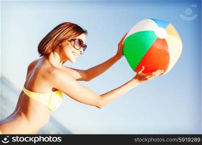 summer holidays, vacation and beach activities concept - girl in bikini playing ball on the beach
