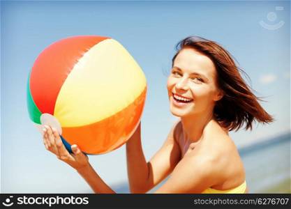 summer holidays, vacation and beach activities concept - girl in bikini playing ball on the beach