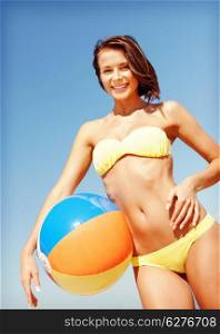 summer holidays, vacation and beach activities concept - girl in bikini with ball on the beach