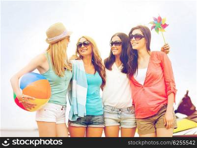 summer holidays, vacation and beach activities concept - smiling girls in shades having fun on the beach