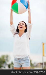 summer holidays, vacation and beach activities - girl playing ball on the beach