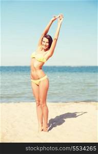 summer holidays, vacation and beach concept - girl in bikini posing on the beach