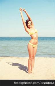summer holidays, vacation and beach concept - girl in bikini posing on the beach