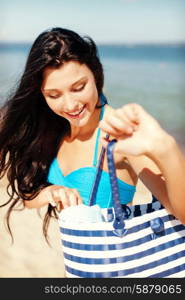 summer holidays, vacation and beach concept - girl in bikini with bag on the beach