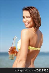 summer holidays, vacation and beach concept - girl with bottle of drink on the beach
