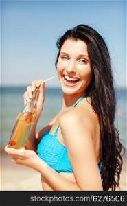 summer holidays, vacation and beach concept - girl with bottle of drink on the beach