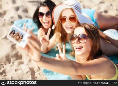 summer holidays, vacation and beach concept - girls taking self photo on the beach