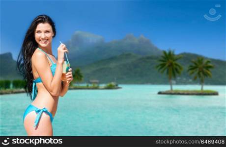 summer holidays, vacation and beach concept - smiling woman in bikini with bottle of non alcoholic drink over bora bora island beach background. woman in bikini with drink on bora bora beach