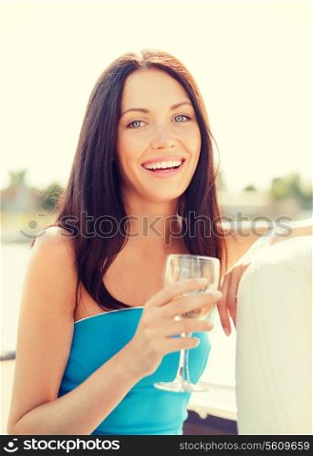 summer holidays, vacation and celebration concept - laughing girl with champagne glass