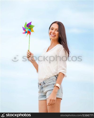 summer holidays, vacation and ecology - girl with windmill toy on the beach