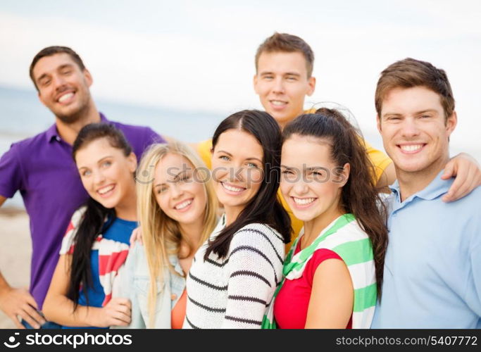 summer, holidays, vacation and happiness concept - group of friends having fun on the beach