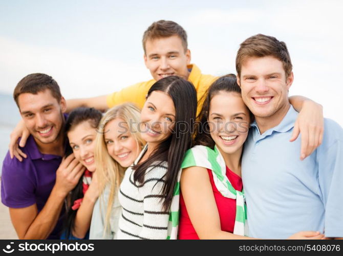 summer, holidays, vacation and happiness concept - group of friends having fun on the beach