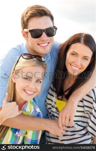 summer, holidays, vacation and happiness concept - group of friends having fun on the beach
