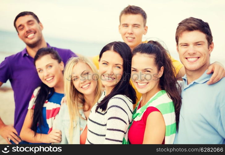 summer, holidays, vacation and happiness concept - group of friends having fun on the beach