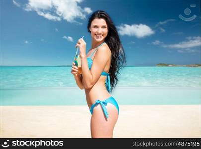 summer holidays, vacation and people concept - happy smiling young woman in bikini with bottle of drink over exotic tropical beach background