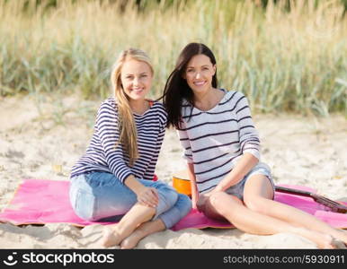 summer holidays, vacation and people concept - happy teenage girls or young women resting on beach