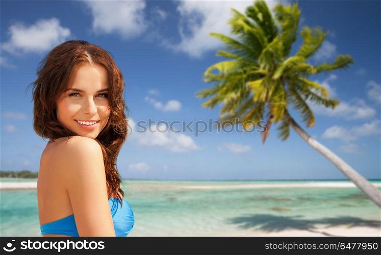summer holidays, vacation and travel concept - happy young woman posing in bikini swimsuit over exotic tropical beach with palm tree background in french polynesia. happy woman in bikini swimsuit on tropical beach. happy woman in bikini swimsuit on tropical beach