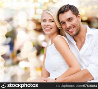 summer holidays, vacation, dating, love and people concept - happy couple having fun over yellow lights background