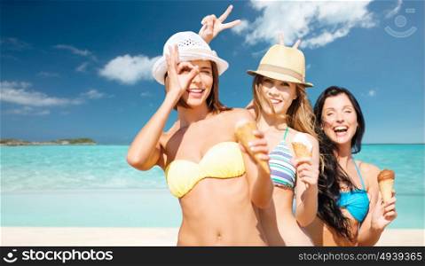 summer holidays, vacation, food, travel and people concept - group of smiling young women in hats eating ice cream over exotic tropical beach with background. group of smiling women eating ice cream on beach