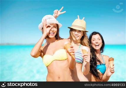 summer holidays, vacation, food, travel and people concept - group of smiling young women eating ice cream on beach over sea and blue sky background. group of smiling women eating ice cream on beach