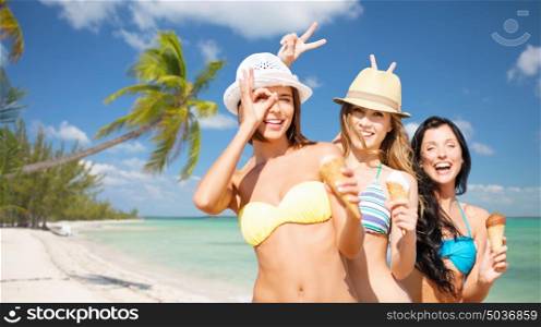 summer holidays, vacation, food, travel and people concept - group of smiling young women in hats eating ice cream over exotic tropical beach with palm trees background. group of smiling women eating ice cream on beach