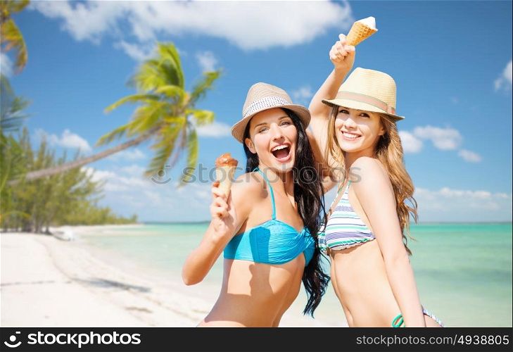 summer holidays, vacation, food, travel and people concept - smiling young women eating ice cream over exotic tropical beach with palm trees background. smiling women eating ice cream on beach