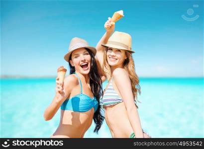 summer holidays, vacation, food, travel and people concept - smiling young women eating ice cream on beach over sea and blue sky background. smiling women eating ice cream on beach