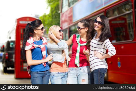 summer, holidays, vacation, friendship and people concept - happy teenage girls or young women in sunglasses talking and laughing over london city street background