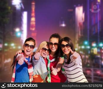 summer, holidays, vacation, happy people concept - beautiful teenage girls or young women showing thumbs up in night city street