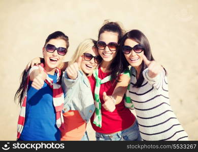 summer, holidays, vacation, happy people concept - beautiful teenage girls or young women showing thumbs up