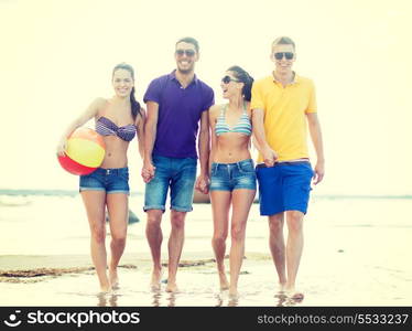 summer, holidays, vacation, happy people concept - group of friends having fun playing with ball on the beach