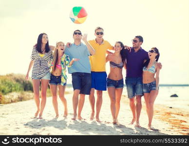 summer, holidays, vacation, happy people concept - group of friends having fun with ball on the beach