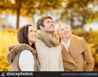 summer, holidays, vacation, happy people concept - group of friends having fun in autumn park
