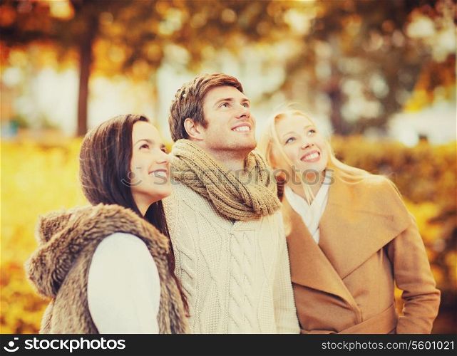 summer, holidays, vacation, happy people concept - group of friends having fun in autumn park