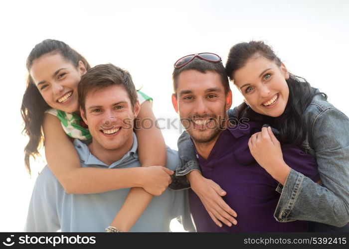 summer, holidays, vacation, happy people concept - group of friends having fun on the beach