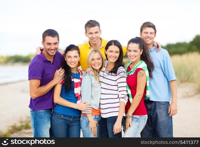 summer, holidays, vacation, happy people concept - group of friends having fun on the beach